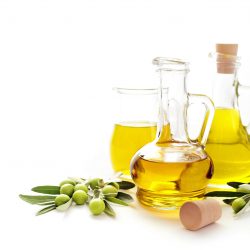 bottle of olive oil and green olives on white background